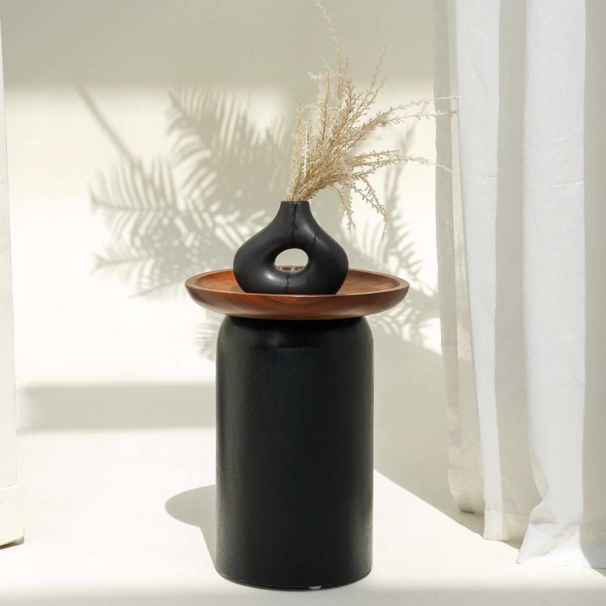 Donald side table with black cylinder base and Suar wood tray top